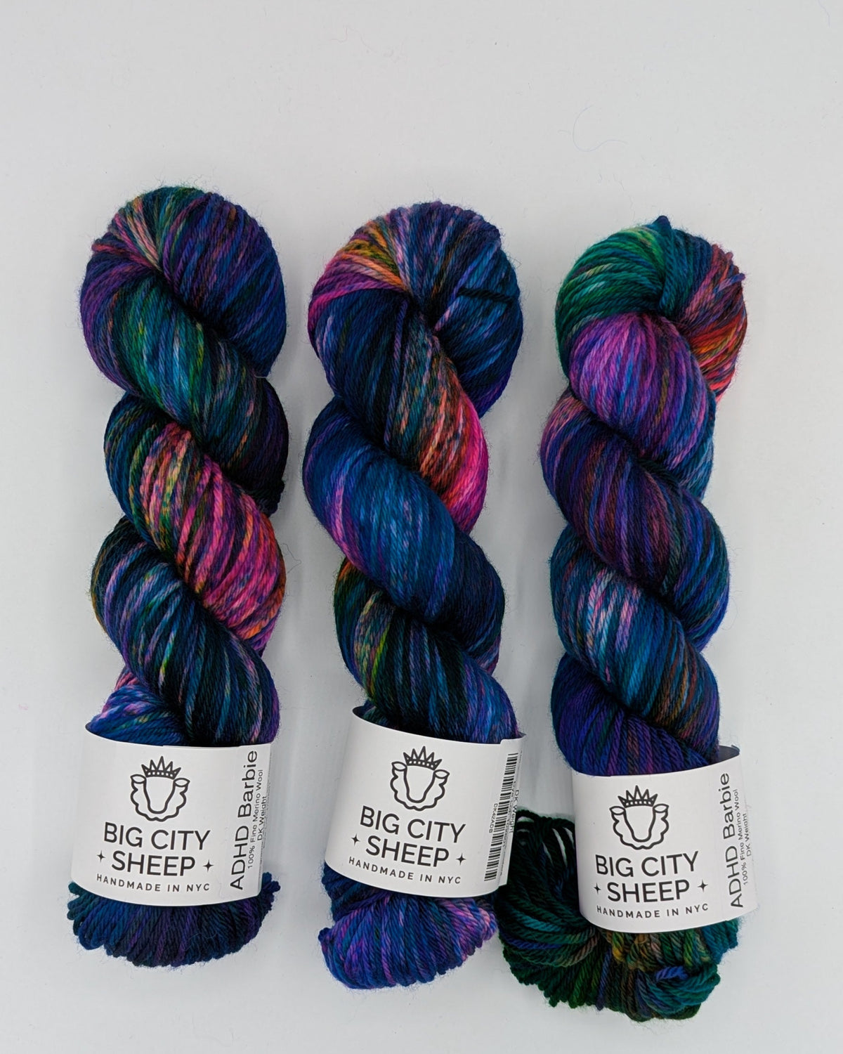 Three skeins of variegated yarn from Big City Sheep displayed side-by-side on a white background.
