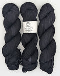 Three skeins of dark charcoal gray yarn with a white paper label in the center that reads 'BIG CITY SHEEP - HANDMADE IN N.Y.